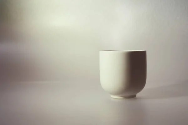 Japanese tea cup on the table near the window.