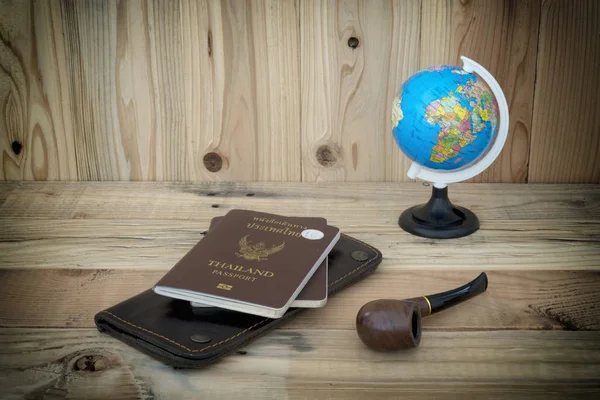 passport and globe with tobacco pipe