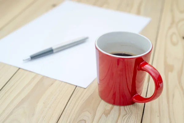 Tasse rouge de café sur le bureau en bois . — Photo