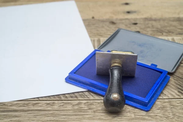 Sello de goma con la tinta azul en el papel blanco — Foto de Stock