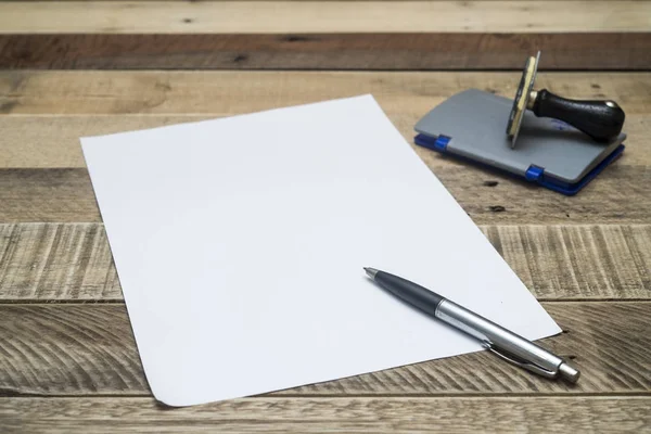 Stift auf weißem Papier mit Stempel auf Holzgrund. — Stockfoto