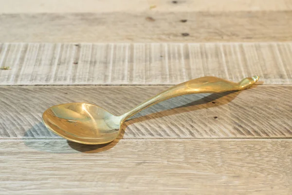 Cucharón de latón aislado en mesa de madera — Foto de Stock