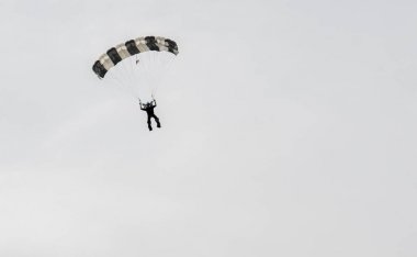 Paraşütçü üzerinde mavi gökyüzü inişe hazırlanıyor
