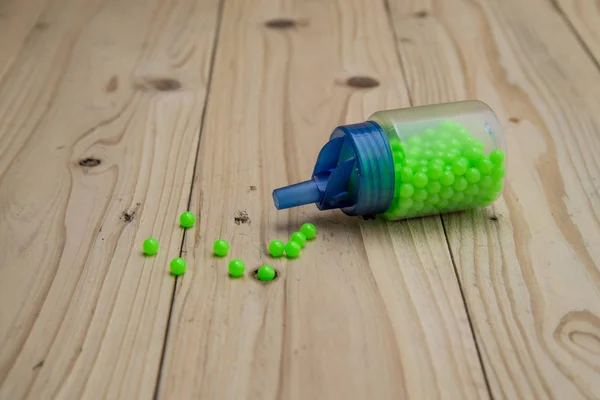 Green Ball Bullet Gun Wooden Table — Stock Photo, Image