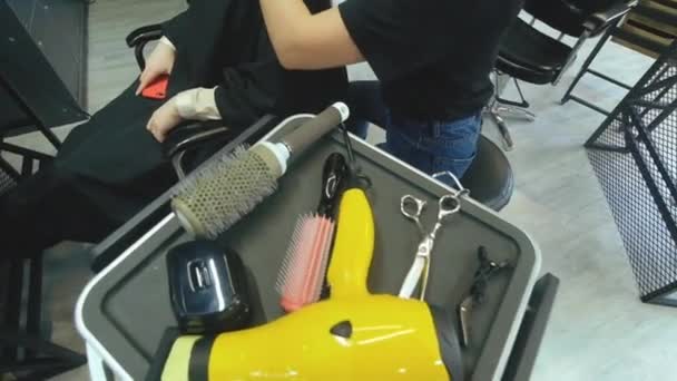 Перукар-перукар з розчісуванням волосся жіночого клієнта. Жінка в перукарні салону краси . — стокове відео