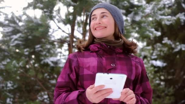 Женщина с ipad в зимнем лесу — стоковое видео