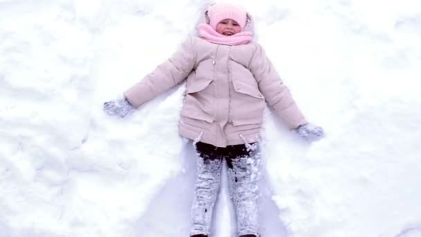 Glad liten flicka i varma kläder i vinter utomhus — Stockvideo