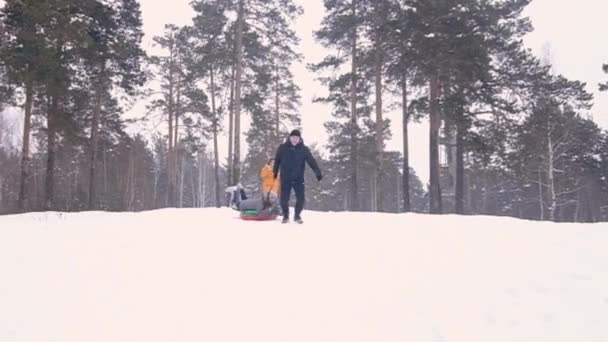 Groep gelukkige vrienden glijdend van op sneeuw buizen — Stockvideo