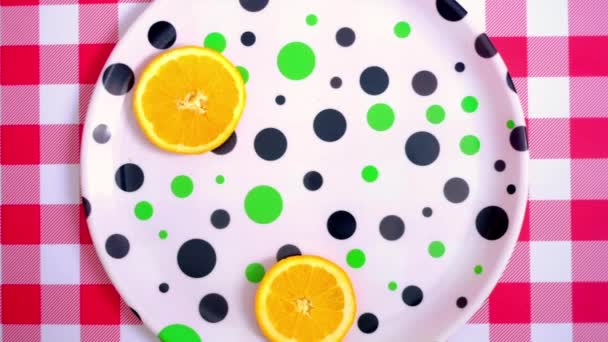 Остановите анимацию движения на тарелке. Нарезанные сочные апельсины — стоковое видео