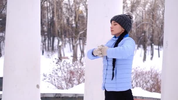 Kışın açık havada yoga jimnastiği yapan genç bir kadın. — Stok video