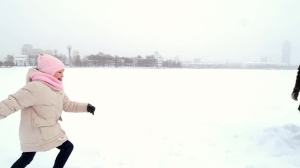 Padre y madre caminan con su pequeña hija en el invierno en la ciudad . — Vídeos de Stock