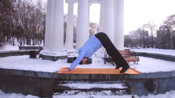 Jonge vrouw oefenen yoga gymnastiek in de winter buiten — Stockvideo