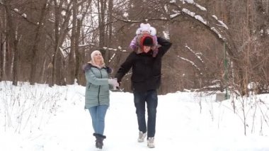 Genç ebeveynler çocuk kışıyla birlikte yürüyorlar. Bebeğim.