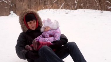 Tepeye tırmanan çocuklu bir adam.