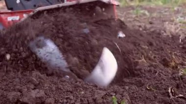 Motor ekiciyle toprağı kazan bir adam..