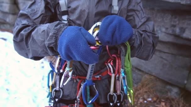 Alpinista que usa arnês de segurança, corda e equipamento de escalada, imagem de close-up — Vídeo de Stock