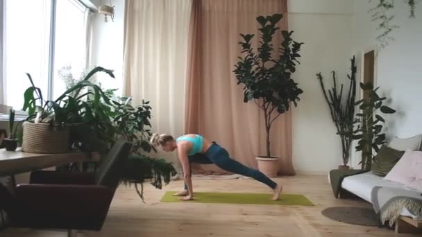 Joven hermosa mujer haciendo yoga en casa — Vídeo de stock