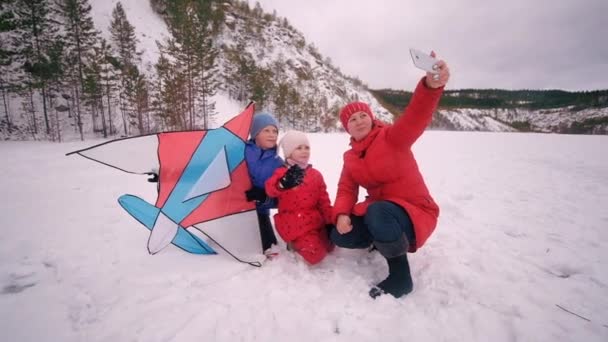 Glücklich, junge Familie spaziert, macht Fotos in der Schlucht. Winterlandschaft — Stockvideo