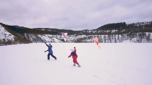 Τα παιδιά τρέχουν με χαρταετό. Χειμερινό τοπίο — Αρχείο Βίντεο