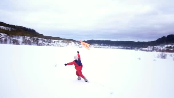 Gelukkig klein meisje met een vlieger. Winterlandschap — Stockvideo