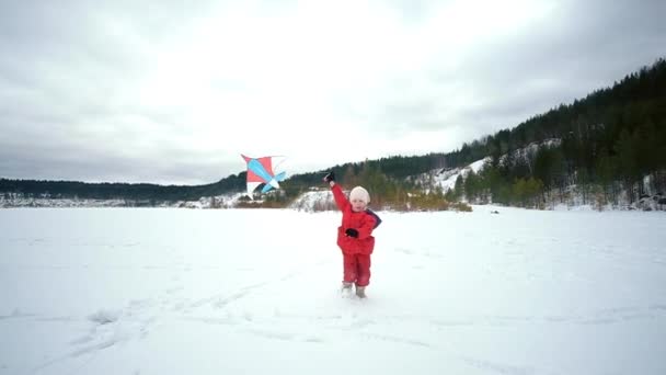 Happy little girl with a kite. Winter landscape — Stock Video