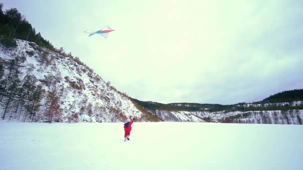 快乐的小女孩，带着风筝。冬季景观 — 图库视频影像