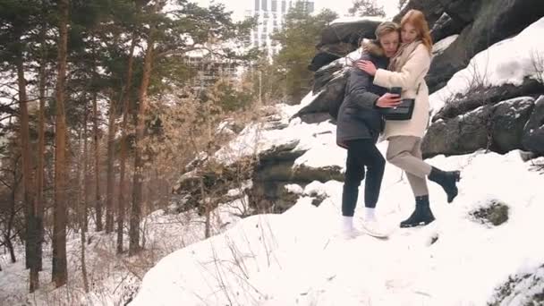 Genç çift kışın kayalıklarda fotoğraf çekiliyor. — Stok video