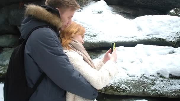 这对年轻夫妇冬天在岩石前拍照 — 图库视频影像