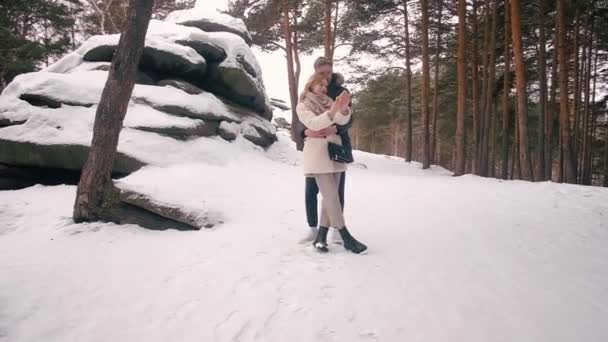 Νεαρό ζευγάρι φωτογραφίζεται το χειμώνα στα βράχια — Αρχείο Βίντεο