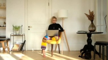 Evde bilgisayar başında oturan kadın.