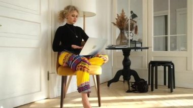 Evde bilgisayar başında oturan kadın.