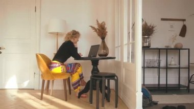 Evde bilgisayar başında oturan kadın.