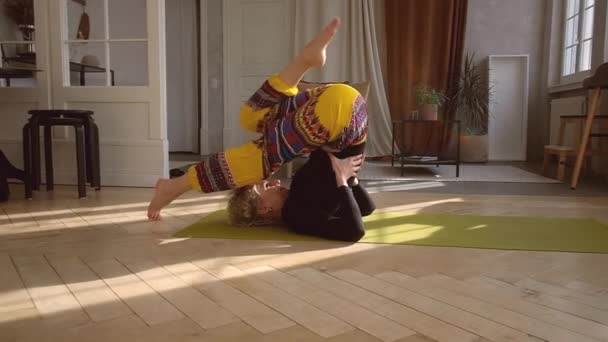 Mladá krásná žena dělá jógu doma. — Stock video