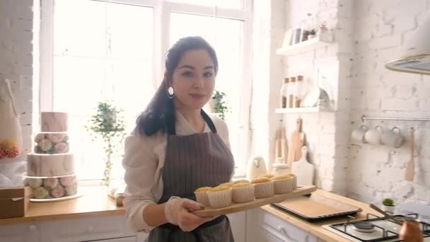 Nő süt cupcakes a konyhában — Stock videók