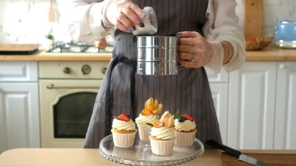 Chefs de postres mano femenina decora deliciosos panecillos con azúcar glaseado . — Vídeos de Stock