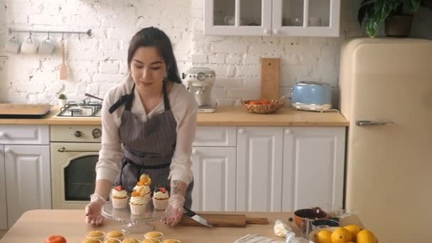 菓子屋の女性はカップケーキを飾る。台所で — ストック動画