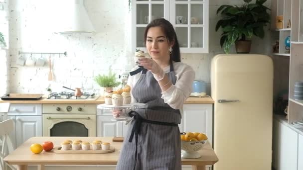 Confectioner woman decorates cupcakes. On the kitchen. — Stock Video