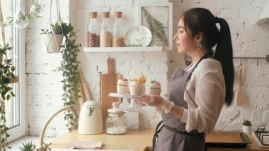 Şekerci kadın kekleri süslüyor. Mutfakta..