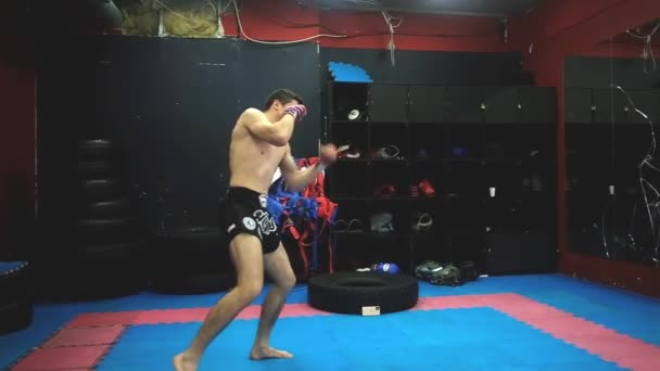 O Kickboxer está a treinar no ginásio. vista de perfil. Boxe tailandês . — Vídeo de Stock