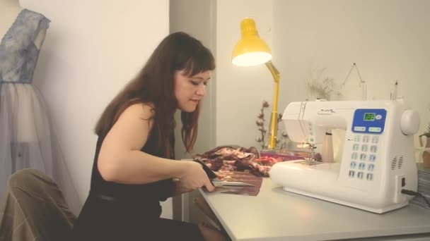 Vrouwelijke kleermaker snijdt stoffen. Naaiatelier — Stockvideo