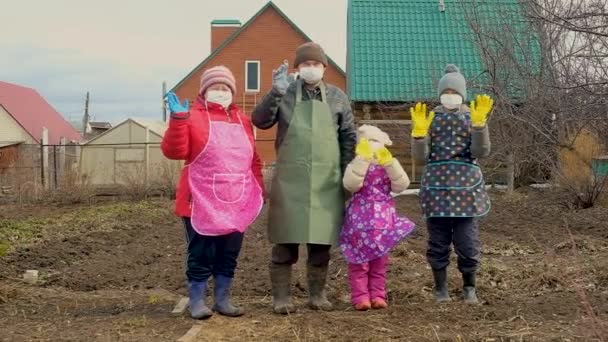 Бабушка, дедушка с внуками в медицинской маске и перчатках для прогулки по стране. Коронавирус — стоковое видео