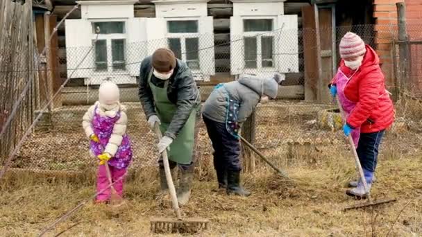 Großmutter, Großvater mit Enkeln in medizinischer Maske und Handschuhen für einen Spaziergang auf dem Land. Coronavirus — Stockvideo