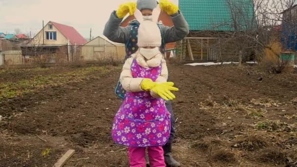 Menino e menina em uma máscara médica e luvas para um passeio no jardim, no país. Coronavírus — Vídeo de Stock