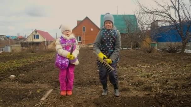 Садівник хлопчик і дівчинка катаються на ковзанах. Пробуджуй, розважайся, дурню. Початок садівництва . — стокове відео