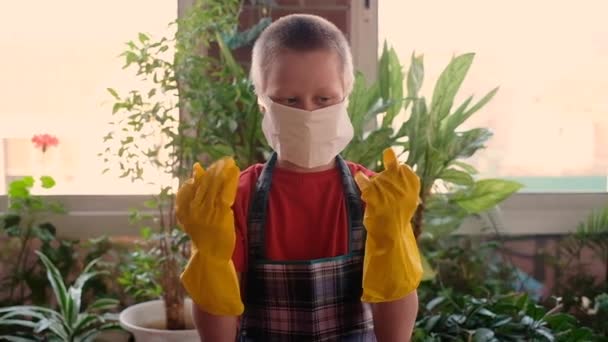 Teenager chlapec v ochranné masce a ochranné gumové rukavice flákání kolem, baví, raduje se. Coronovirus. — Stock video