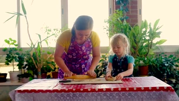 30歳の幸せな女性と就学前の女の子がケーキを作る。現代的なキッチンで一緒に家のパン屋料理を準備する2人の笑顔の家族. — ストック動画