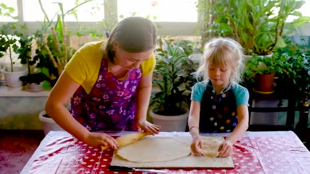 Mulher feliz de 30 anos de idade e uma pequena filha da idade pré-escolar cozinhar um bolo. Família sorridente de dois preparando comida de padaria em casa juntos em uma cozinha moderna . — Vídeo de Stock