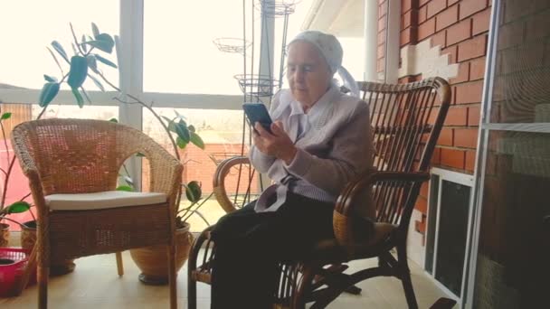 Babička drží mobilní telefon na obrazovce. Starší žena — Stock video