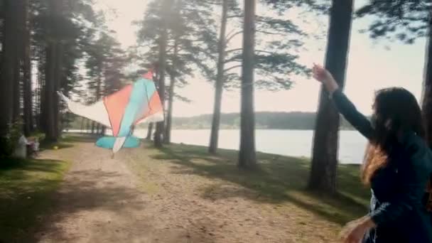 Une fille dans un masque médical avec un cerf-volant court à travers le parc . — Video