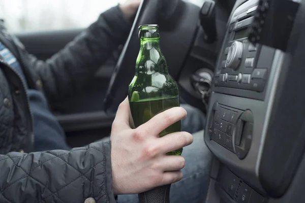 Young man driving his car while drinking alcohol — Stock Photo, Image